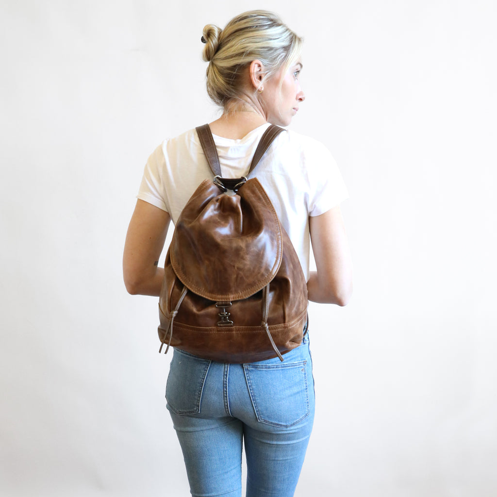 Back view of model wearing 1904 maxwell, size large, as a backpack. 