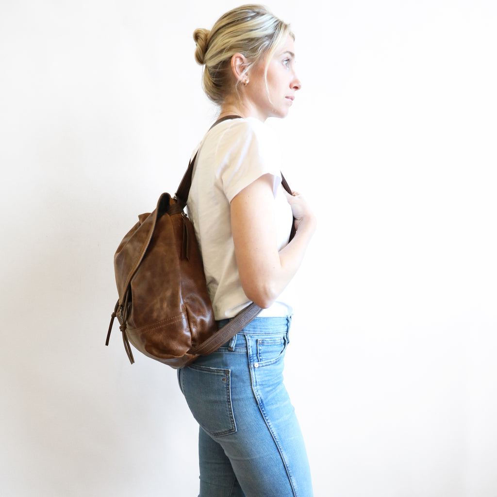 Side view of model wearing 1904 maxwell, size large, as a backpack. 
