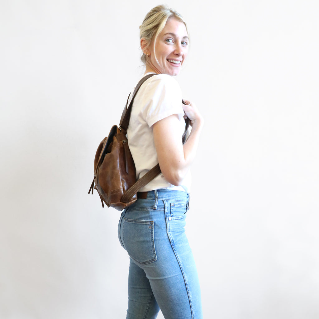 Side view of model wearing 1904 maxwell, size small, as a backpack. 