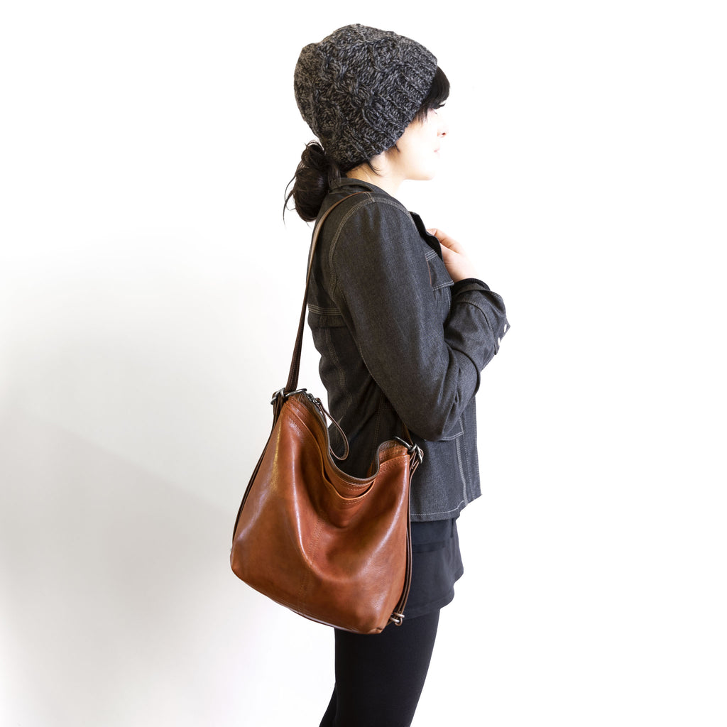 Model holding a hobo pack original on shoulder, in size small, for size demonstration. The size of the hobo pack open pocket is approximately the same as the city safari original. 
