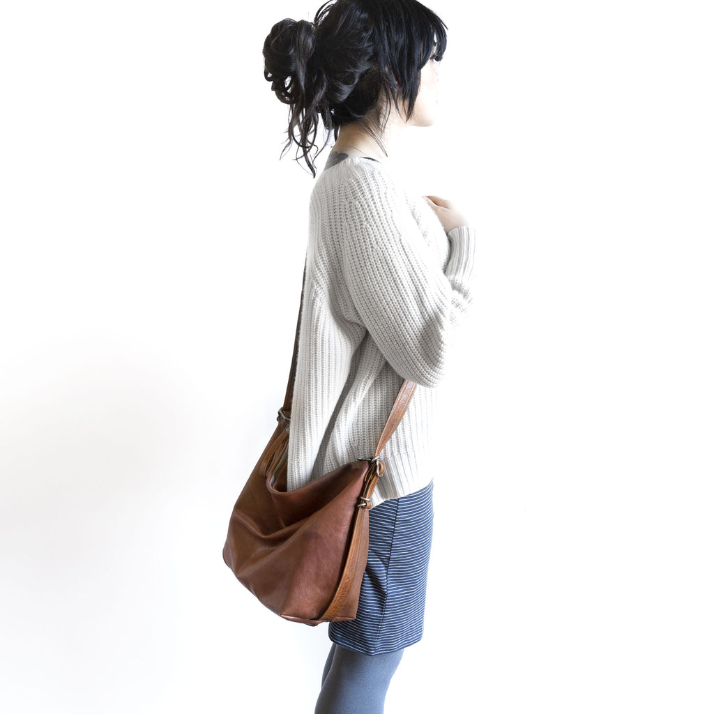 Model with a hobo pack original, size medium, showing strap adjusted to crossbody length. 