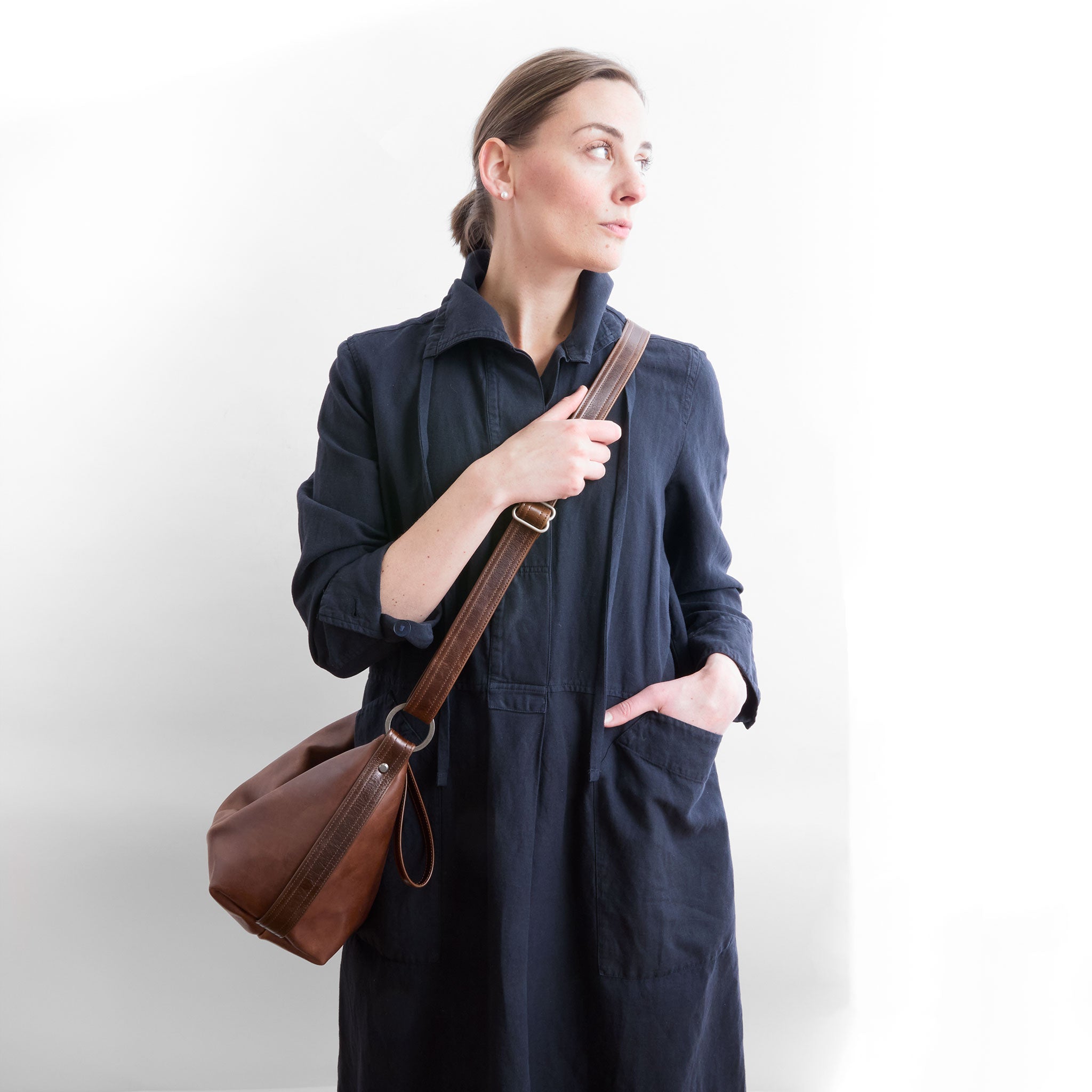 beau duffel in pure saddle being worn as crossbody