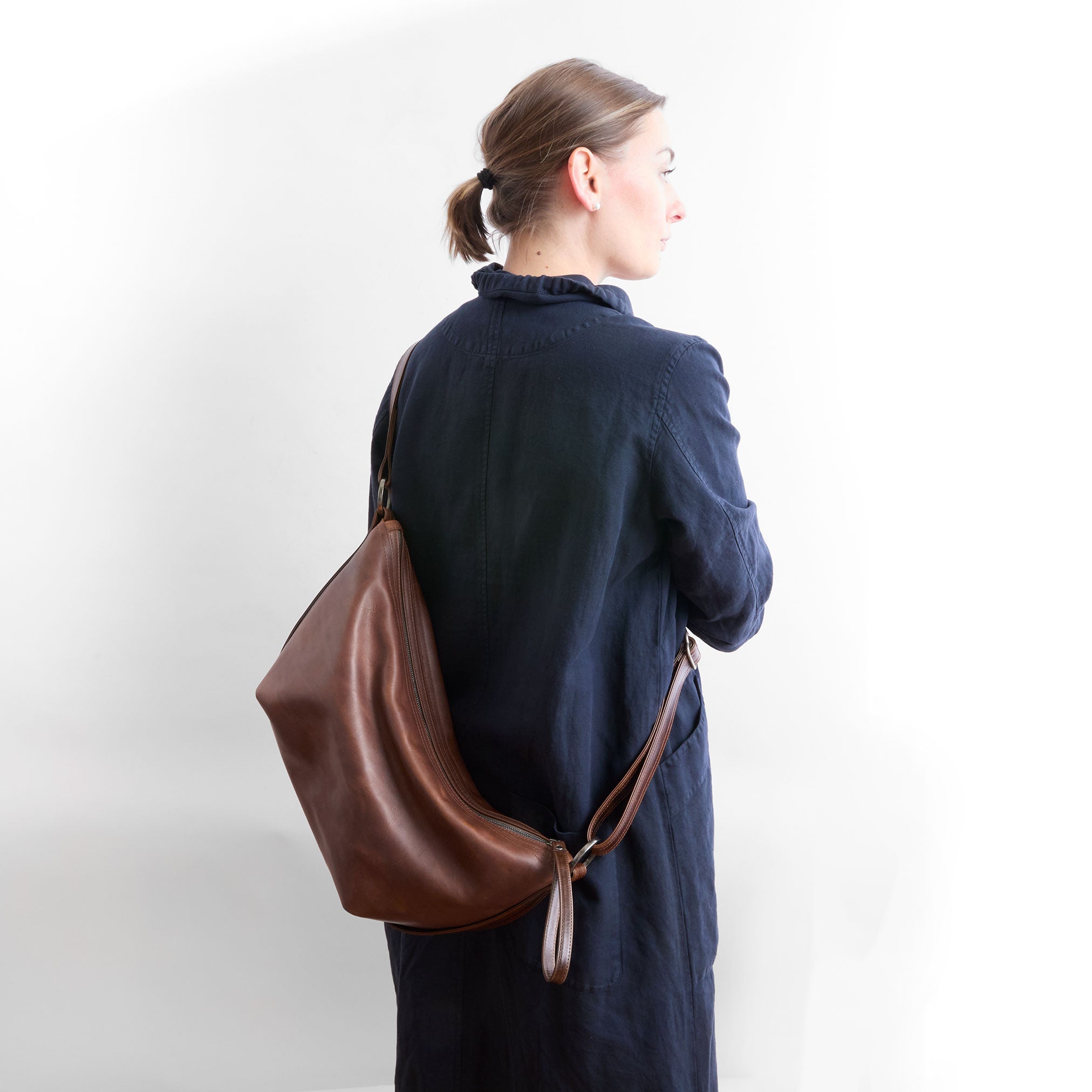 beau duffel in pure saddle being worn as crossbody style