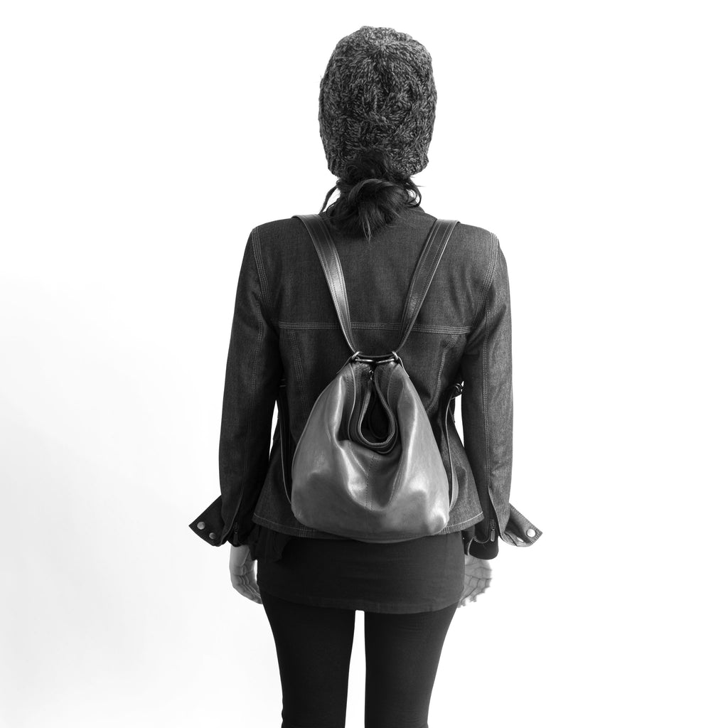 Model wearing a hobo pack open pocket as a backpack, in size small, for size demonstration. The size of the small hobo pack open pocket is approximately the same as the small original city safari waxed canvas and leather. 