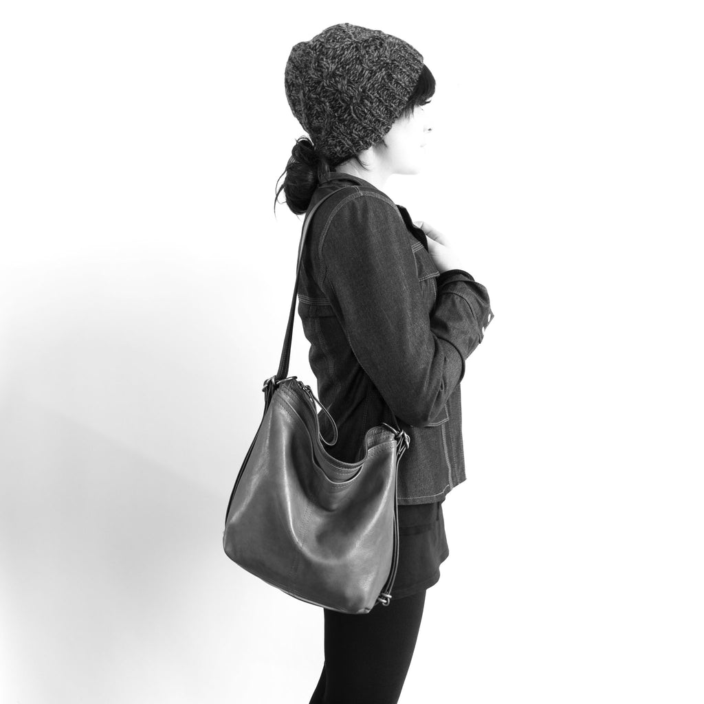Model wearing a, size small, hobo pack open pocket on shoulder. The size of the small hobo pack open pocket is approximately the same as the small original city safari waxed canvas and leather. 