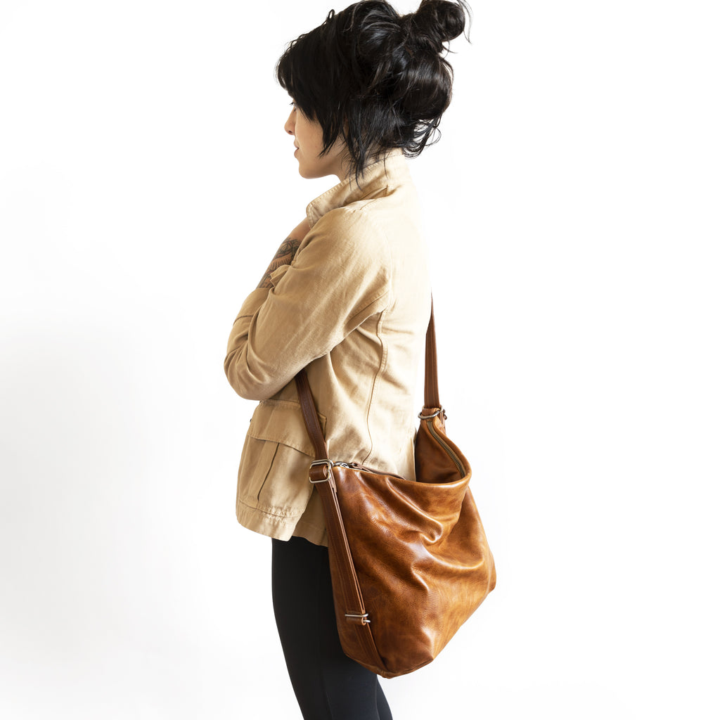 Model with a hobo pack original, size large, showing strap adjusted for crossbody carry. 