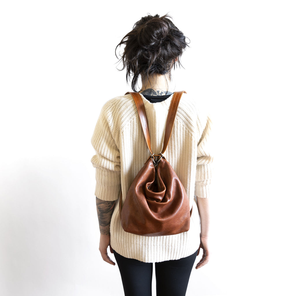 Model with a hobo pack original, size small, showing strap adjusted for backpack carry. 