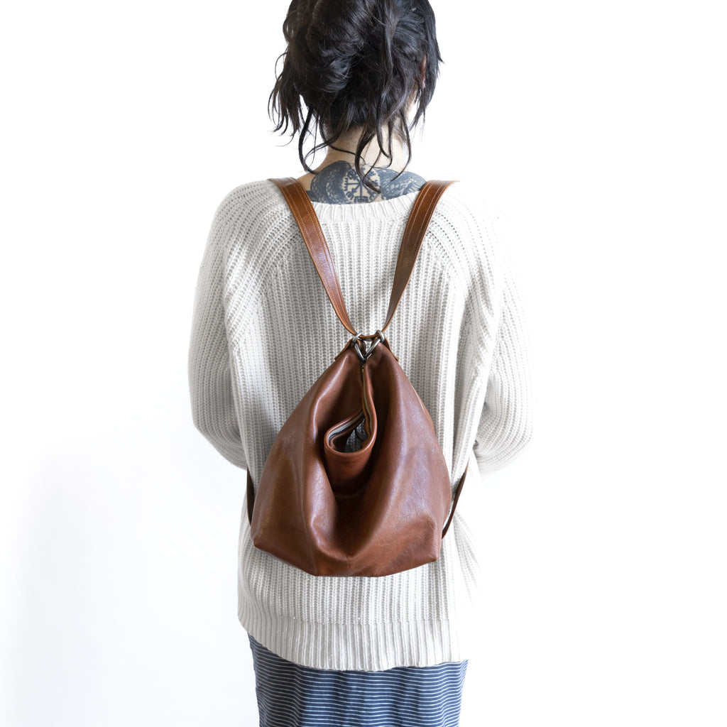 Model with a hobo pack original, size medium, showing strap adjusted for backpack carry. 