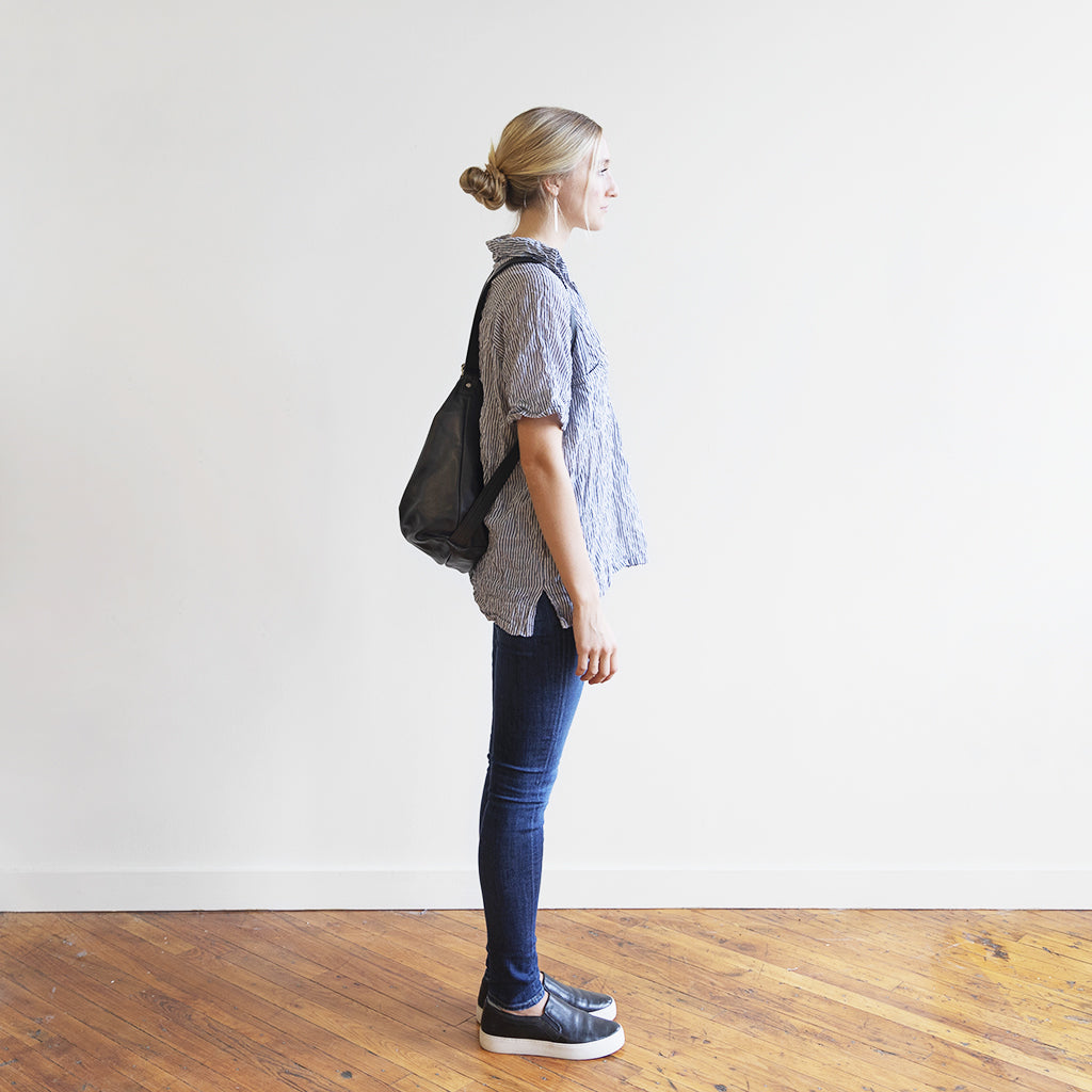 Model with a hobo pack original, size extra large, showing strap adjusted for backpack carry. 