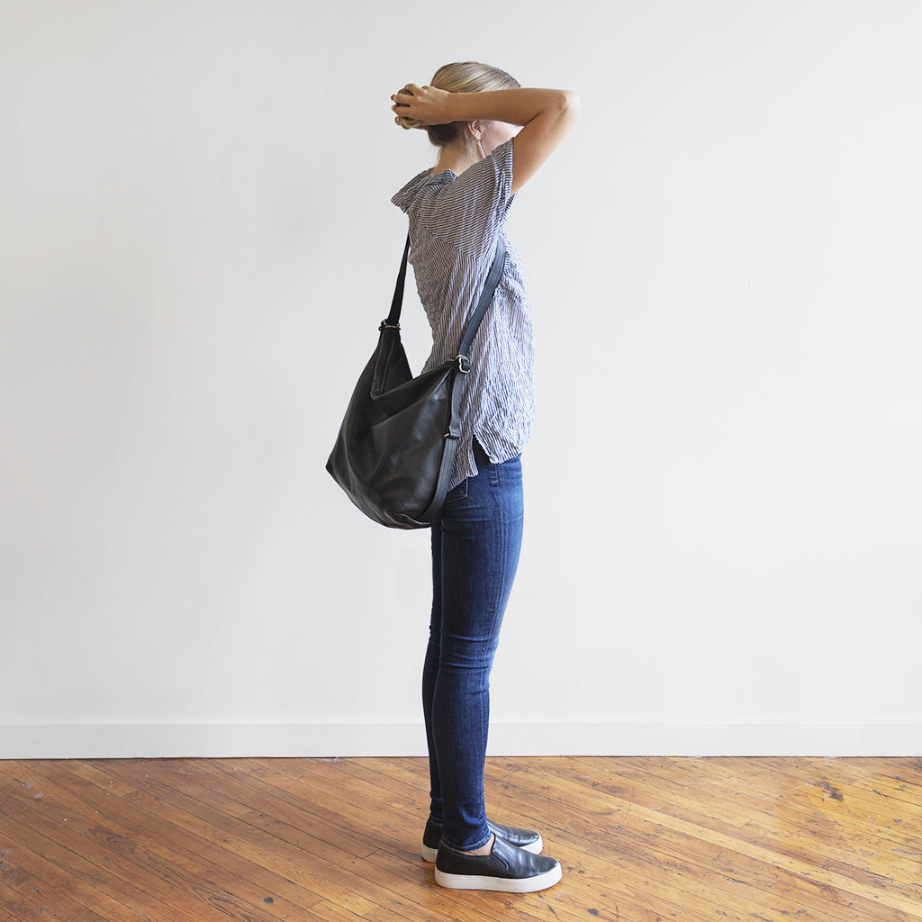 Model with a hobo pack original, size extra large, showing strap adjusted to crossbody length. 